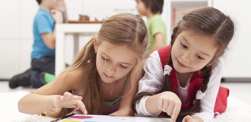 两个年轻的女孩在平板电脑上学习